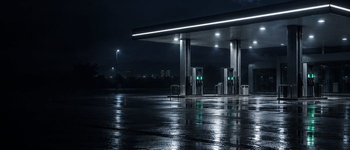 Автозаправочная станция ночью, навес над колонками и освещённая площадка